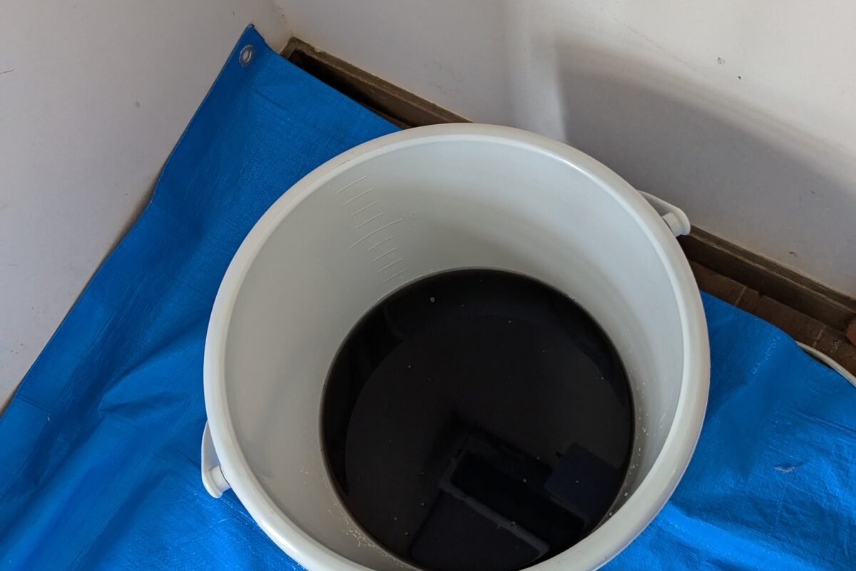 エアコンクリーニングで出た真っ黒な汚水が溜まったバケツ