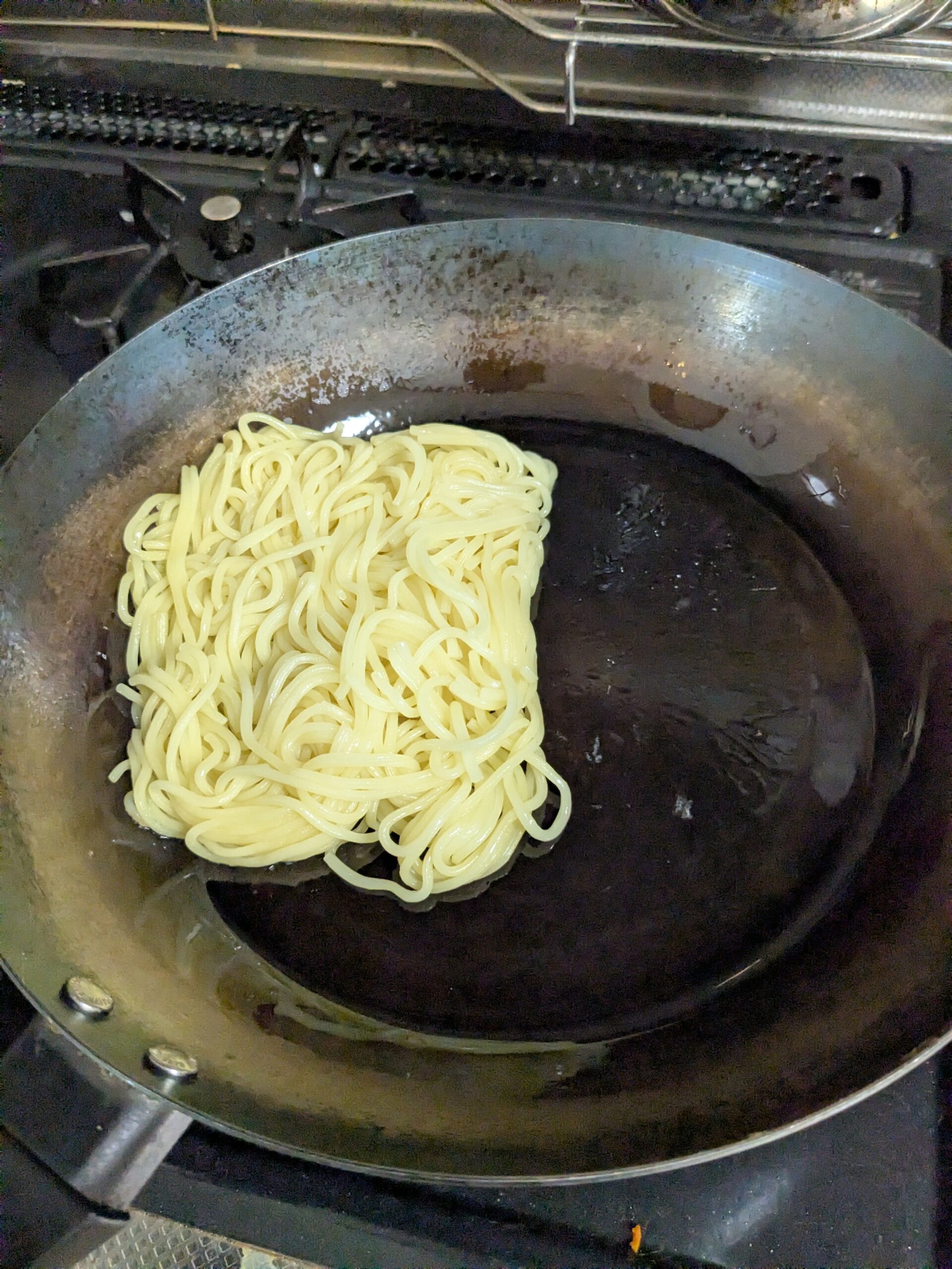 油をたっぷり入れた鉄フライパンで麺だけを炒めているところ