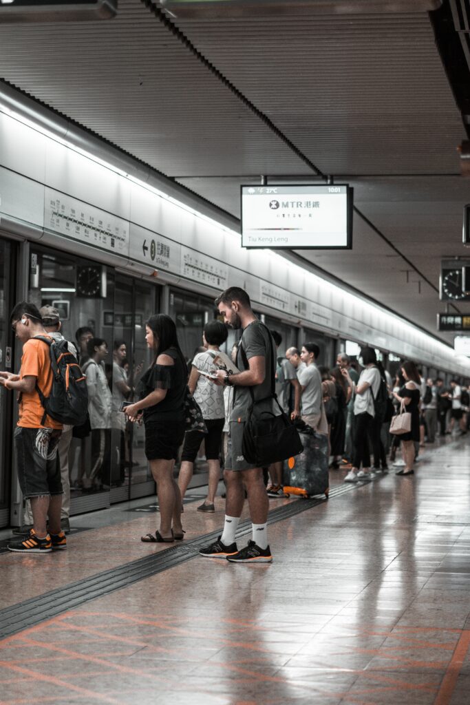 駅のホームで電車を待つ人たち