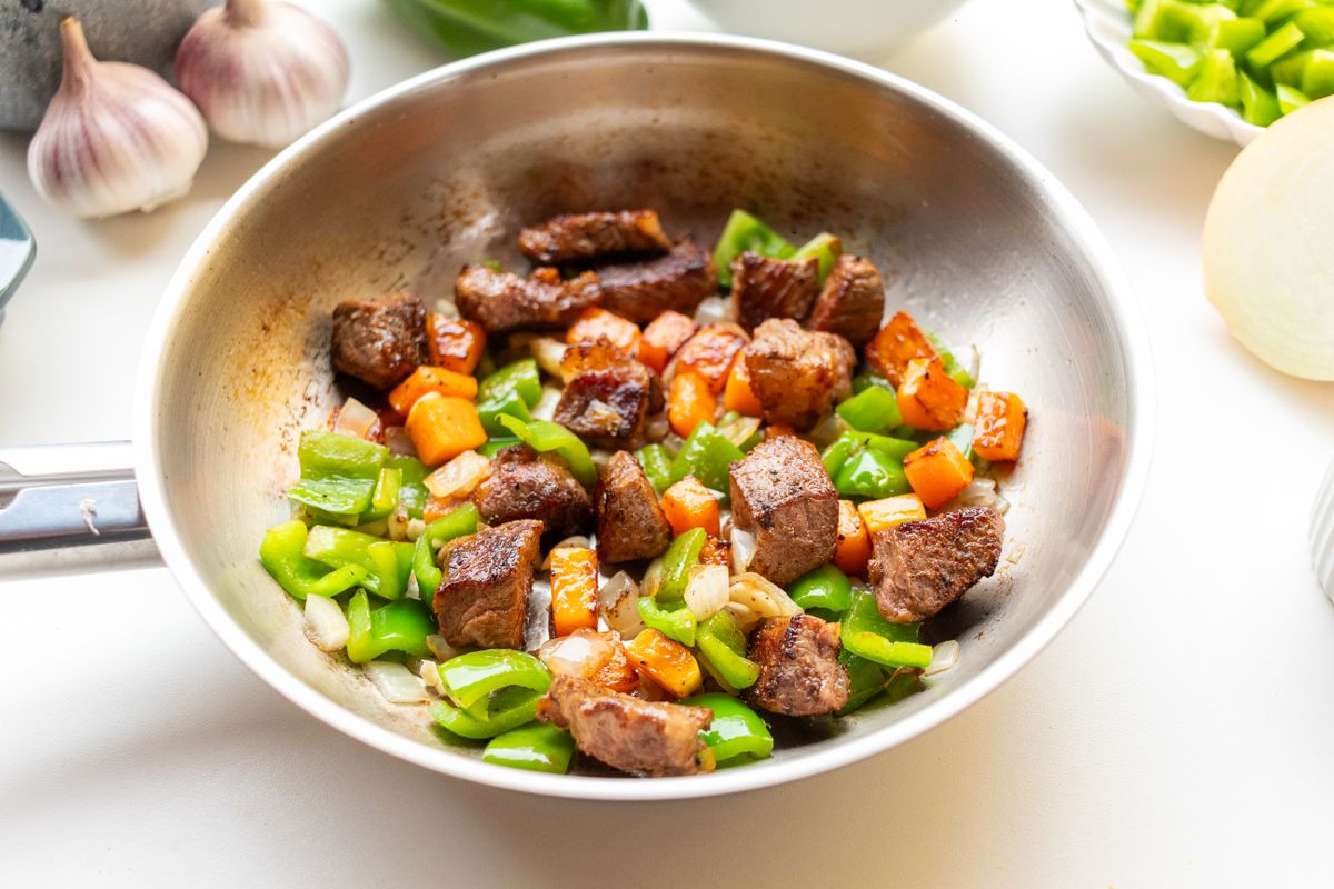フライパンで肉と野菜を炒めているところ