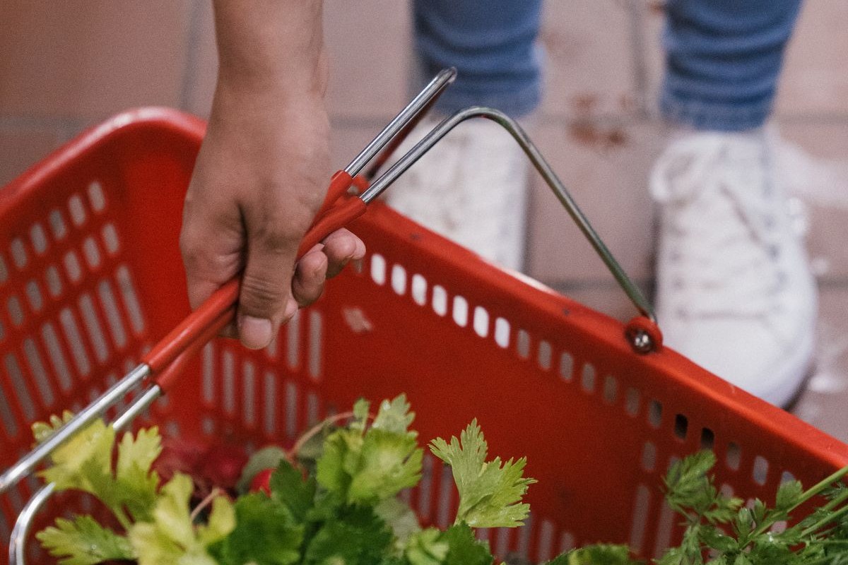 買い物かごに野菜を入れている手元