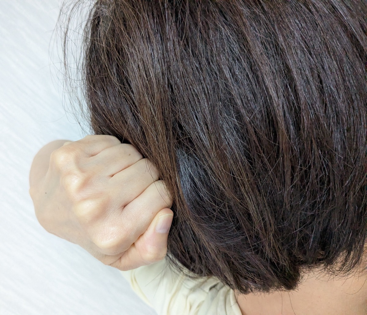 ゲンコツの出っぱった関節を、後頭部の生えぎわに当てているところ
